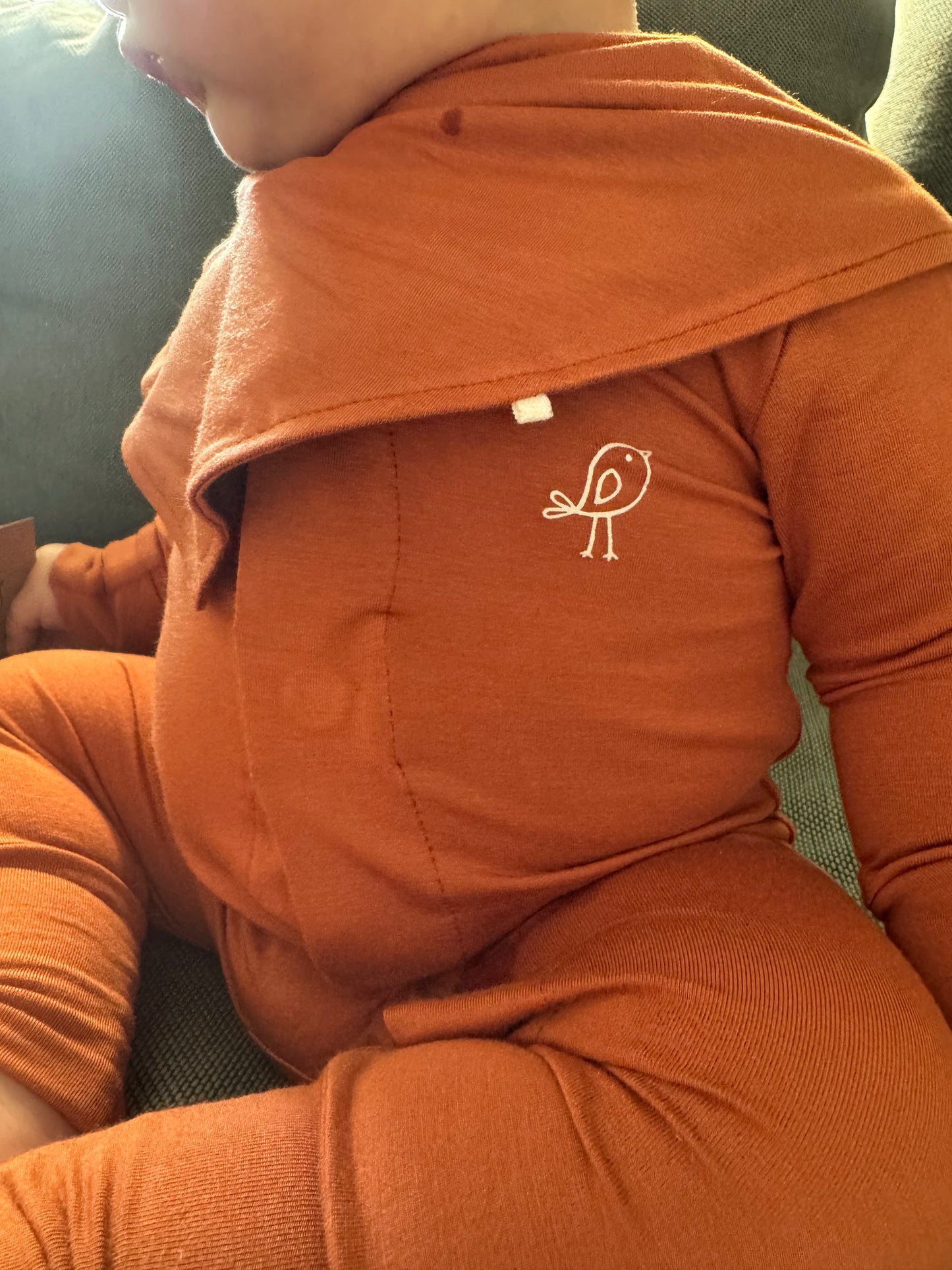 Terracotta orange magnetic baby bamboo bib - lifestyle photo on baby model