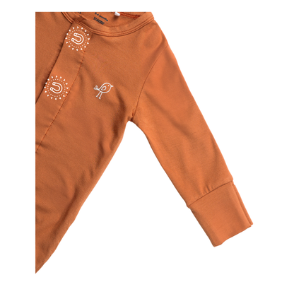 Birdie terracotta sleepsuit showing soft sleeve and embroidered bird logo and magnetic closure