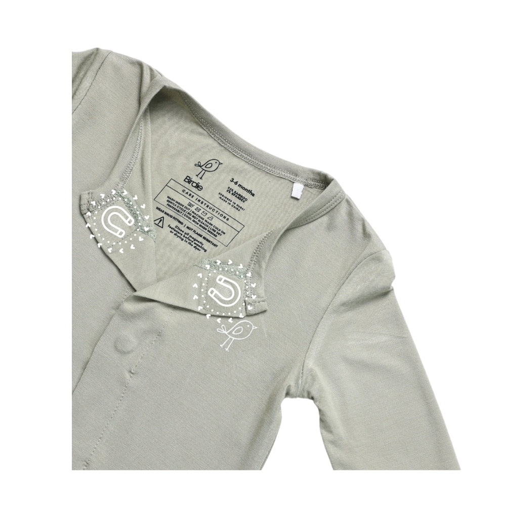 Birdie green sage sleepsuit showing soft sleeve and embroidered bird logo and magnetic closure