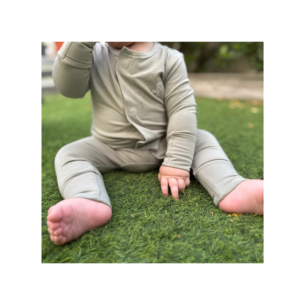Baby wearing Birdie sage green bamboo sleepsuit with magnetic closure and soft stretch convertible feet and mittens
